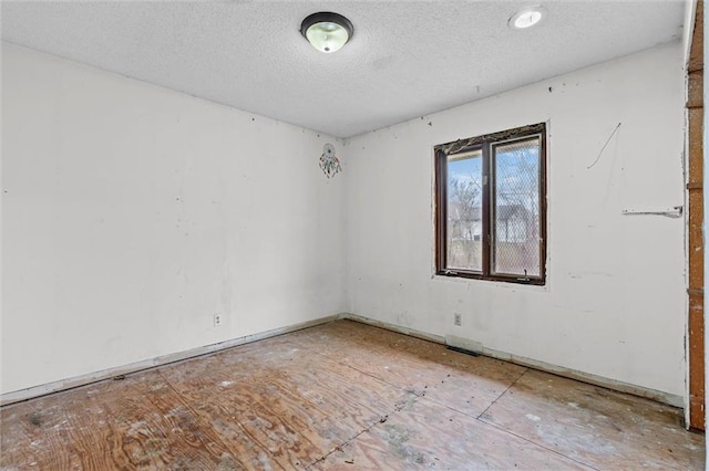 unfurnished room with a textured ceiling