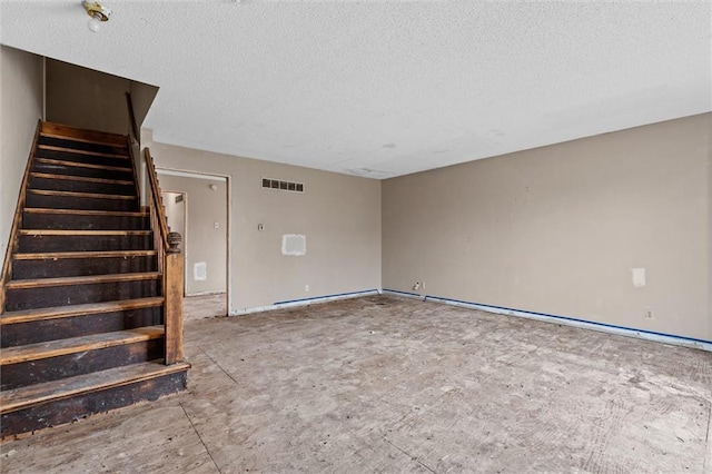 interior space with stairs, visible vents, and a textured ceiling