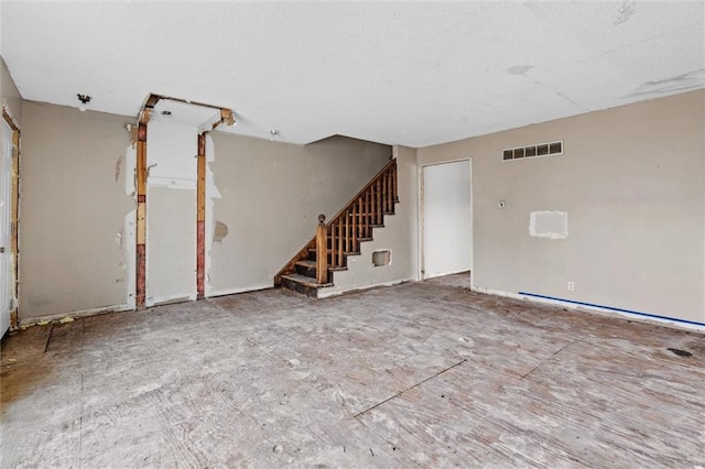 spare room with stairway and visible vents