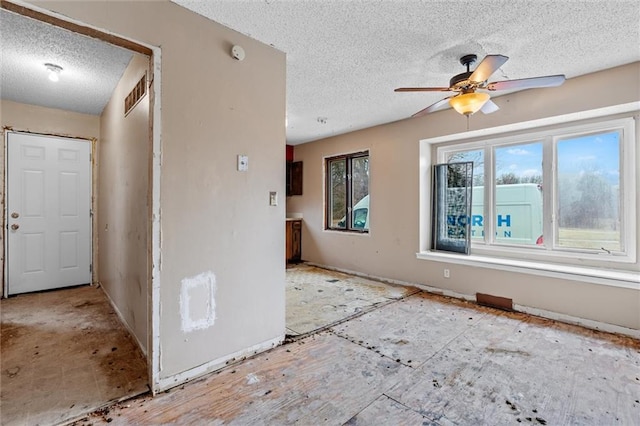 empty room featuring ceiling fan and a textured ceiling