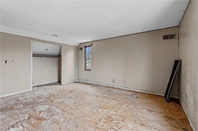 unfurnished bedroom featuring a closet, visible vents, and a textured ceiling