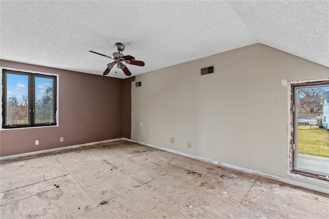 spare room with ceiling fan, visible vents, vaulted ceiling, and a wealth of natural light