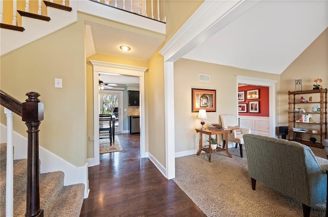 entrance foyer featuring visible vents, ceiling fan, stairway, a wainscoted wall, and dark wood-style floors