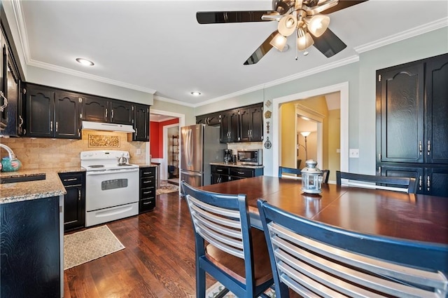 kitchen with under cabinet range hood, a sink, backsplash, stainless steel appliances, and dark wood-style flooring