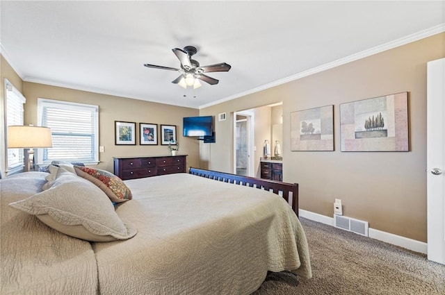 carpeted bedroom featuring visible vents, ornamental molding, ensuite bathroom, baseboards, and ceiling fan