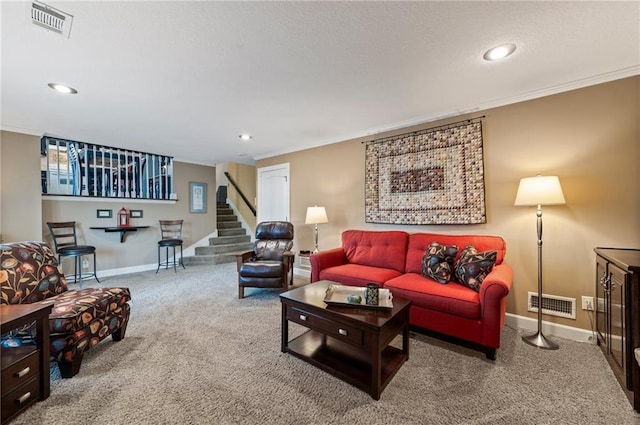 carpeted living room with crown molding, stairway, baseboards, and visible vents