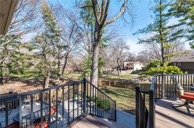 wooden terrace with a lawn and fence