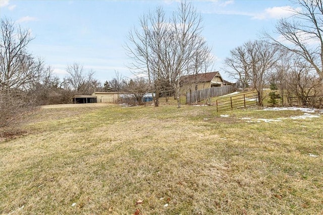 view of yard with a pole building, fence, and an outdoor structure