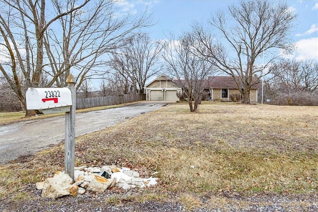 exterior space featuring aphalt driveway, an attached garage, and fence