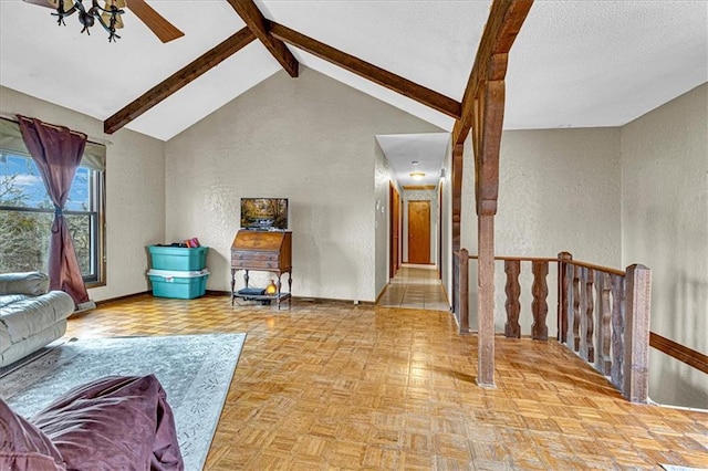 living area featuring a textured ceiling, a textured wall, high vaulted ceiling, baseboards, and beamed ceiling