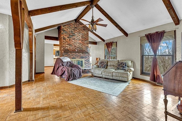 living area featuring baseboards, a textured wall, ceiling fan, vaulted ceiling with beams, and a fireplace