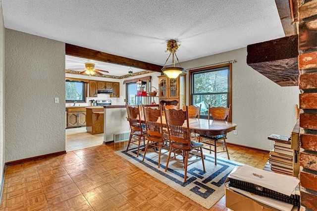 dining space featuring visible vents, a textured wall, a textured ceiling, and baseboards