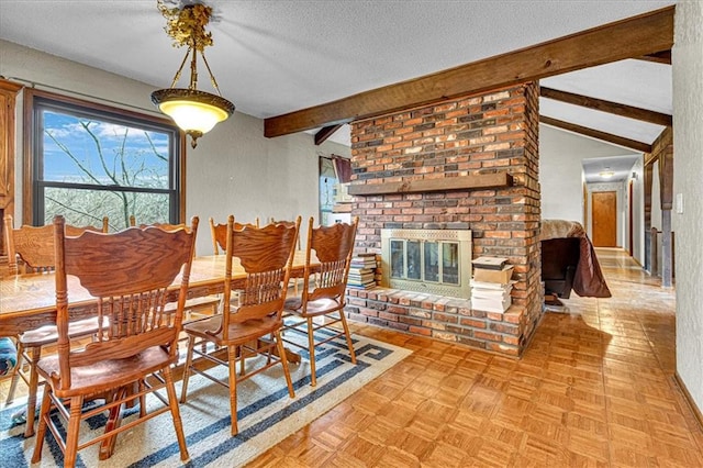 dining space with a fireplace, vaulted ceiling with beams, and a textured ceiling