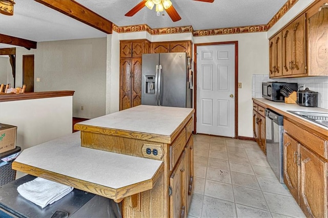 kitchen featuring appliances with stainless steel finishes, brown cabinetry, light countertops, and tasteful backsplash