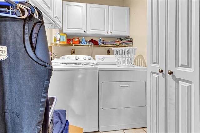 laundry room featuring light tile patterned floors, washing machine and clothes dryer, and cabinet space