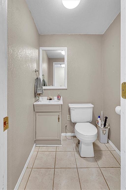 bathroom featuring tile patterned flooring, baseboards, and toilet