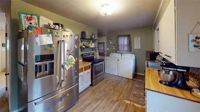 kitchen with washing machine and clothes dryer, light wood-style flooring, a sink, stainless steel appliances, and white cabinetry