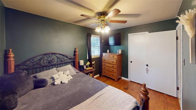 bedroom with baseboards, ceiling fan, and wood finished floors