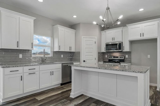 kitchen featuring stainless steel appliances, dark wood-type flooring, a sink, and white cabinets