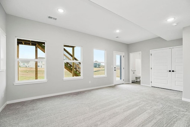 empty room featuring carpet floors, recessed lighting, visible vents, and baseboards