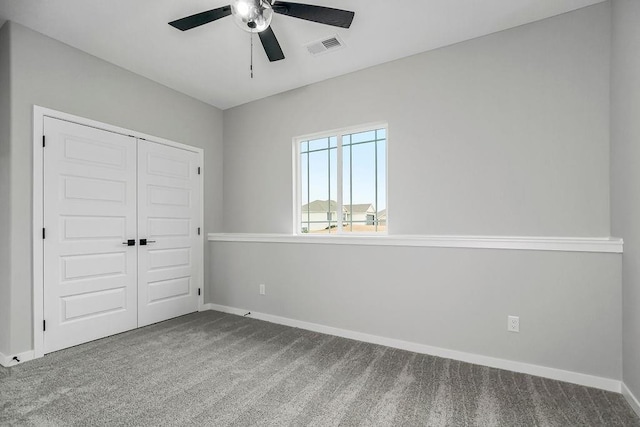 unfurnished bedroom with carpet, a closet, visible vents, ceiling fan, and baseboards