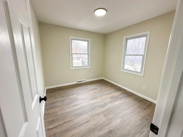 unfurnished bedroom featuring visible vents, baseboards, and dark wood finished floors