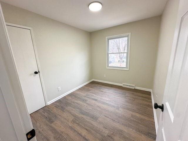 unfurnished room featuring baseboards and wood finished floors