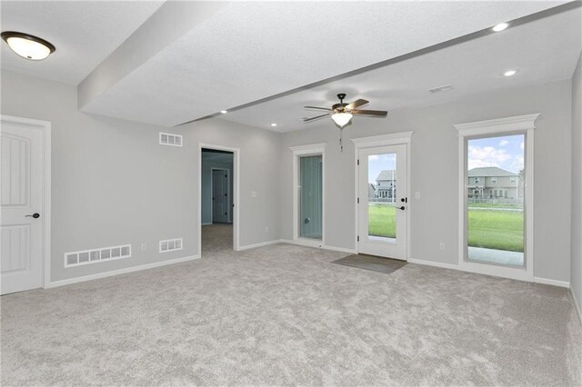 carpeted spare room featuring visible vents, a textured ceiling, and baseboards