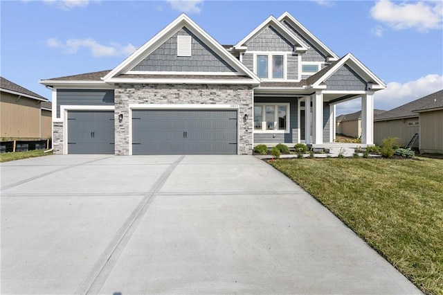 craftsman house featuring a garage, driveway, and a front yard