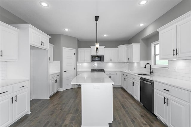 kitchen featuring a kitchen island, a sink, white cabinets, dishwasher, and stainless steel microwave