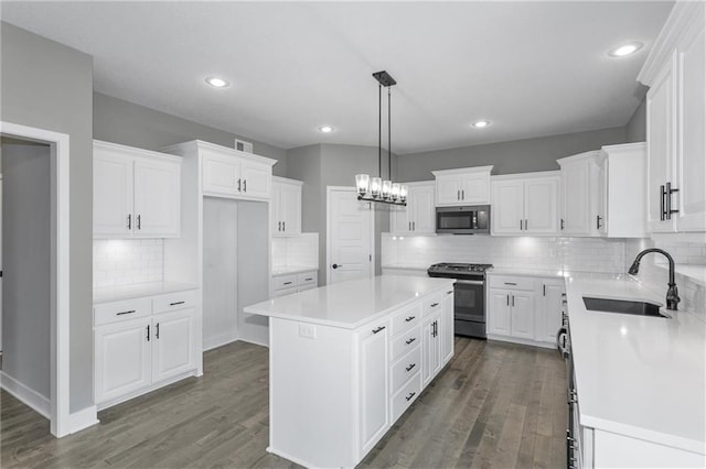 kitchen with a kitchen island, stainless steel range, dark wood-type flooring, and a sink