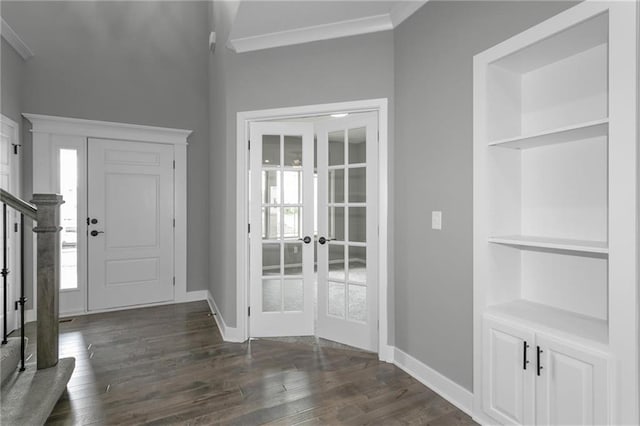 entryway featuring dark wood-style floors, crown molding, stairway, and baseboards