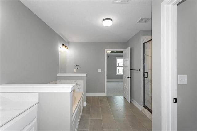 full bath featuring a garden tub, visible vents, a stall shower, vanity, and baseboards