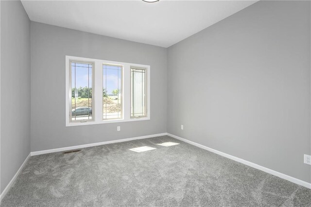 unfurnished room with visible vents, baseboards, and carpet flooring