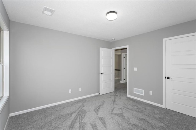 unfurnished bedroom featuring baseboards, visible vents, and carpet flooring