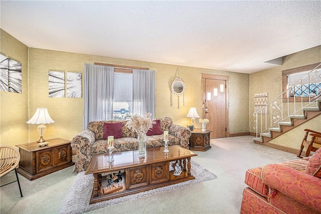 carpeted living area with wallpapered walls, a textured ceiling, stairway, and a wealth of natural light