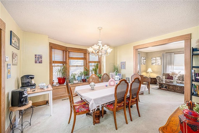 dining area featuring light carpet, a textured ceiling, and an inviting chandelier