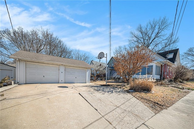 view of property exterior featuring an outbuilding and a detached garage