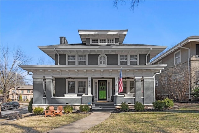 american foursquare style home featuring a front lawn and covered porch