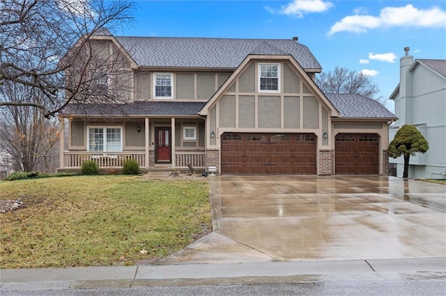 tudor-style house with stucco siding, driveway, a front lawn, a porch, and brick siding