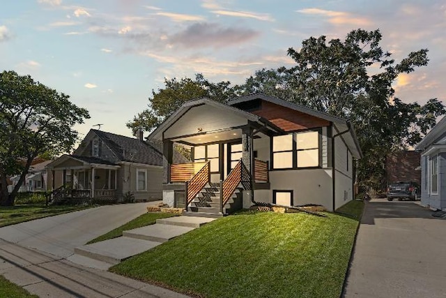 bungalow-style house featuring a front lawn and stucco siding