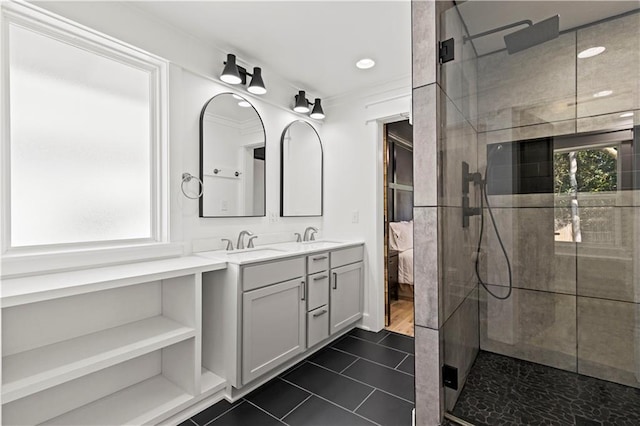 ensuite bathroom with double vanity, a sink, and tiled shower