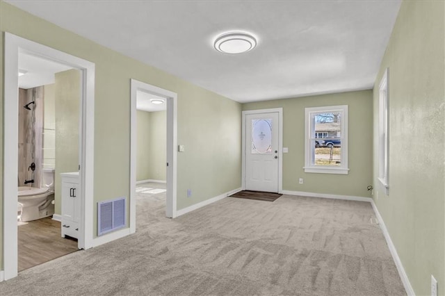 carpeted entrance foyer with baseboards and visible vents