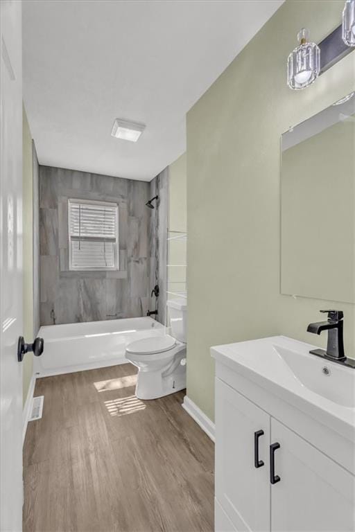 full bathroom featuring baseboards, toilet, bathtub / shower combination, wood finished floors, and vanity