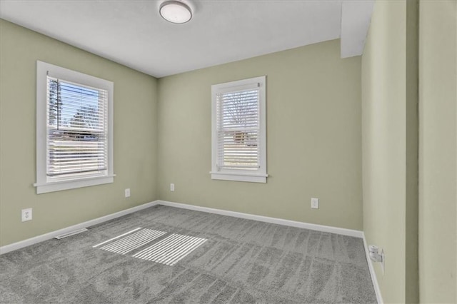 spare room featuring carpet flooring and baseboards