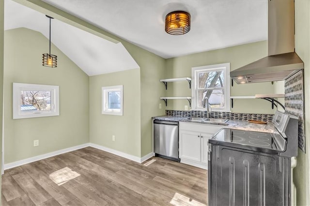 kitchen with open shelves, a sink, plenty of natural light, appliances with stainless steel finishes, and wall chimney range hood