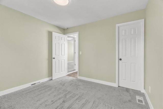 unfurnished bedroom featuring baseboards, visible vents, and carpet floors