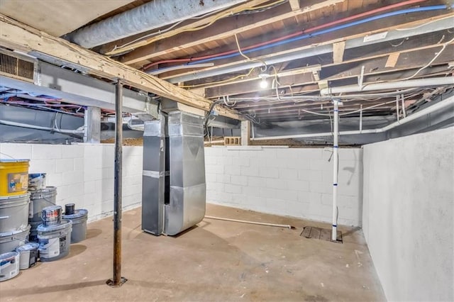 unfinished basement featuring heating unit