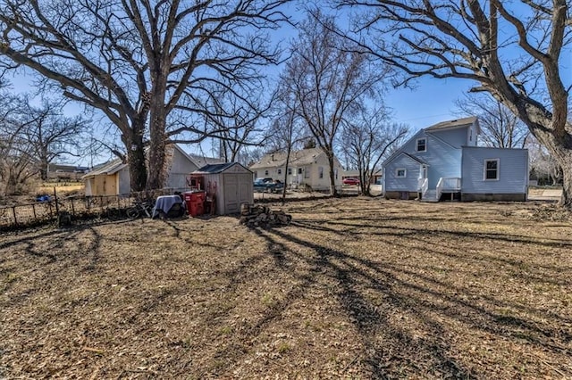 view of yard with a storage shed, fence, and an outdoor structure