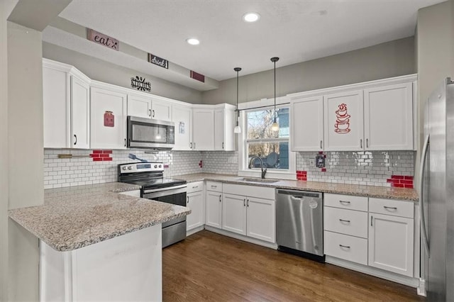 kitchen with white cabinets, dark wood-style floors, appliances with stainless steel finishes, and a sink